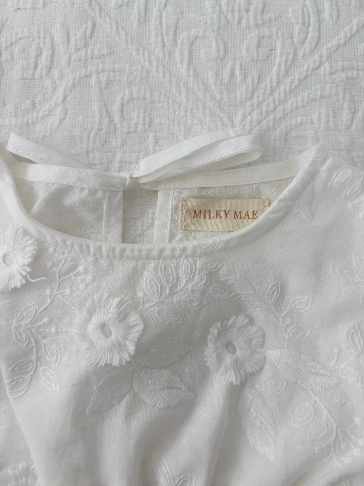 Milky Mae Elaina Romper in cotton fabric with delicate embroidered flowers 